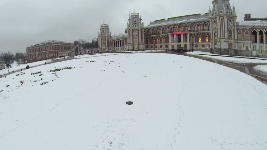 Tourists walk by square near palace of queen Catherine in Tsaritsyno at winter evening in Moscow. Aerial view