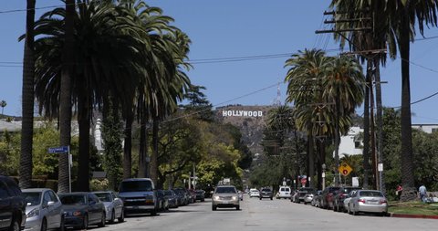 LOS ANGELES, USA - APRIL 3, 2013 Hollywood Sign Los Angeles Entertainment World Symbol Cars Passing Palm Trees ( Ultra High Definition, Ultra HD, UHD, 4K, 2160P, 4096x2160 )