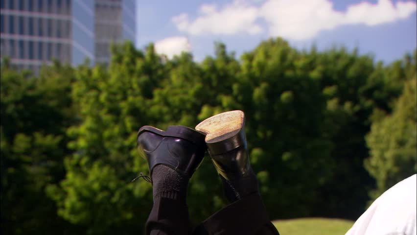feet dangling in front of office building and park