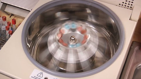 A centrifuge spins vials of liquid in a laboratory test.