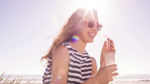 Smiling girl with lemonade at the beach on sunny summer day - Βίντεο στοκ