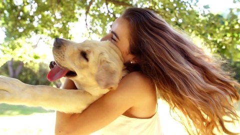 Young woman spinning with her labrador dog in slow motion