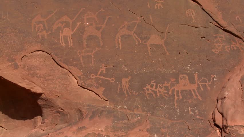 WADI RUM, JORDAN CIRCA 2013 - Ancient and mysterious petroglyphs depict humans and camels in the Saudi desert near Wadi Rum, Jordan.