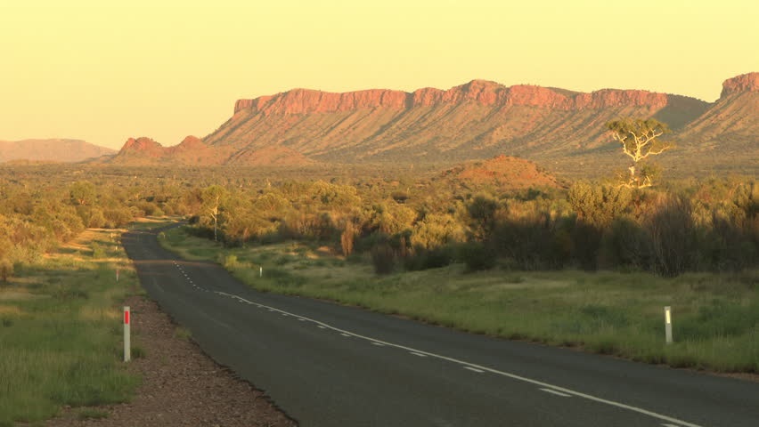 Road through a dusty mountain landscape at dusk