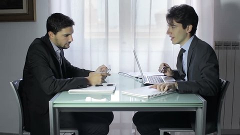 two young businessmen in meeting, two businessmen working on the laptop