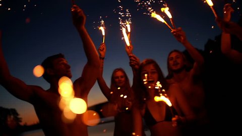 Friends with sparklers dancing in slow motion