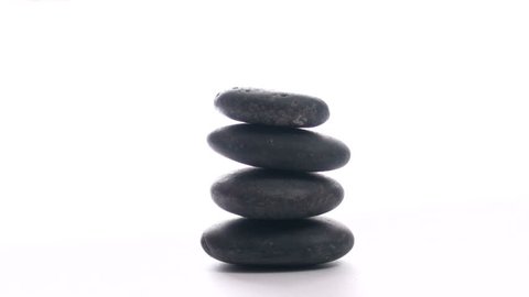 Stacking Zen rocks against white background