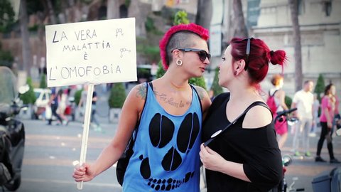 two lesbians kissing in the street demonstrating for their rights - gay pride Video Stok