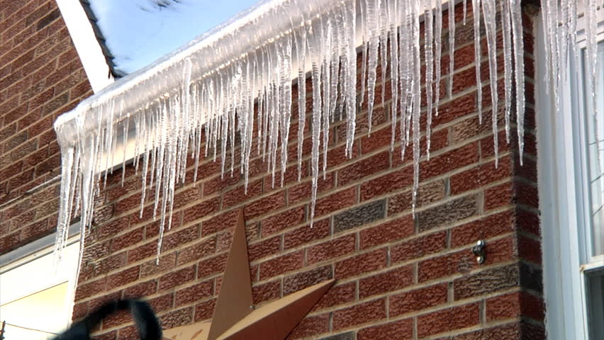 Breaking off dangerous icicles from the roof.