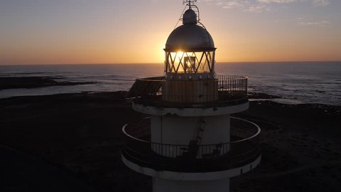AERIAL: Large lighthouse at sunset