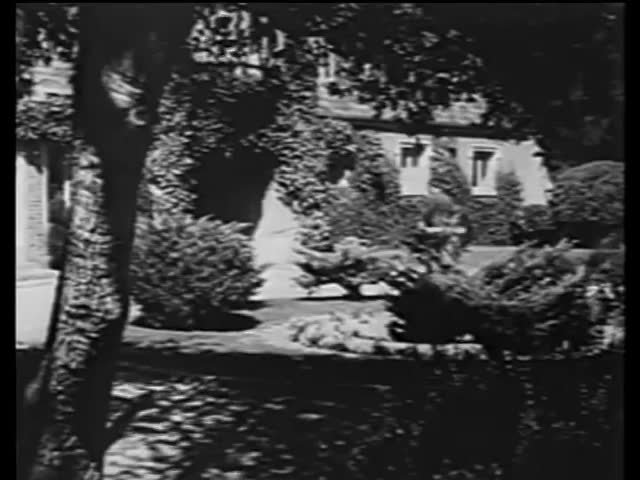 Wide shot of man entering mansion