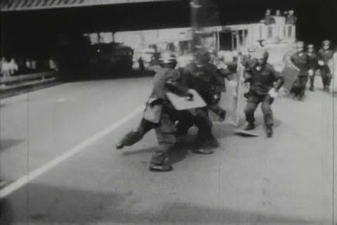 CIRCA 1970s - 1970s black and white footage of students protesting and being attacked by police in Tokyo, Japan