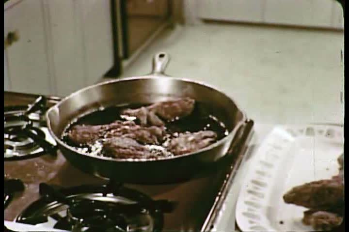 CIRCA 1960s - Two teenage boys hastily prepare food while getting ready to go to a party while two teenage girls do the same thing during the 1960s