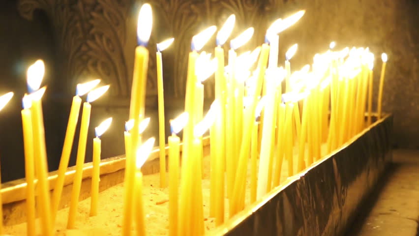 People light candles and put on a stand in the Temple of the Holy Sepulchre
