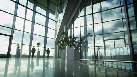 Time lapse of business people and clouds in a light and modern office building