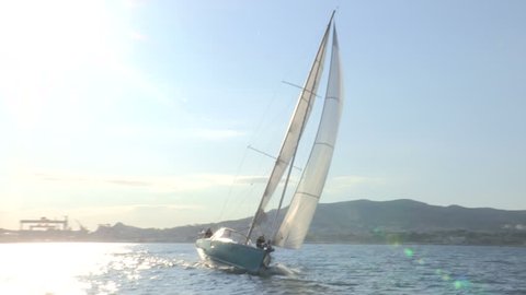 Sailing boat navigating in the sea with open sails
