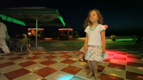 two little girls dancing in night club 