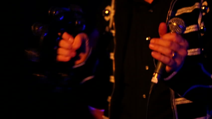 Tambourine player on stage  wearing fancy rock jacket    