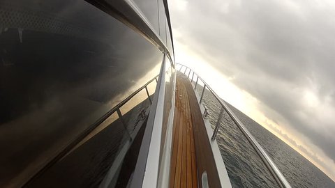 Lateral side of a luxury yacht navigating at the sunset
