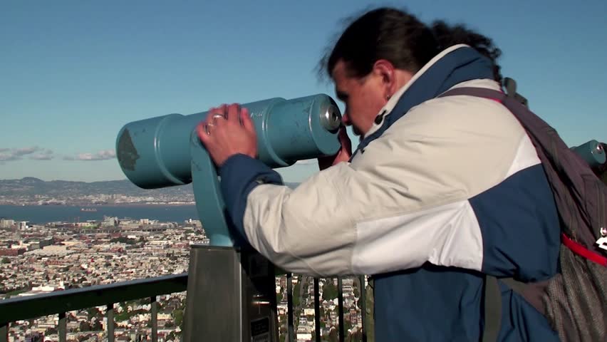 Tourist is looking through a telescopic tower
