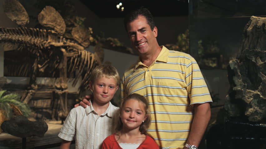Medium Shot Pan Portrait of man with daughter (8-9) and son (10-11) in natural history museum
