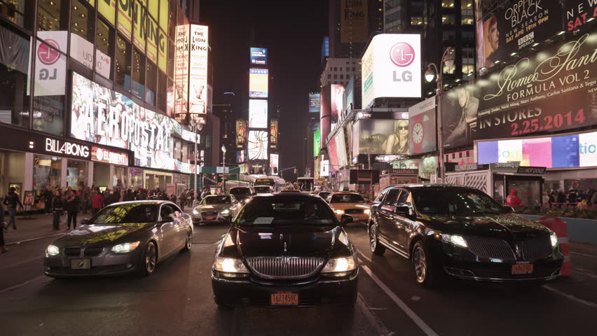 NEW YORK - APRIL 17, 2014: Uber car driving through beautiful Times Square at night in slow motion in 4K in New York. Times Square is an intersection and neighborhood in Midtown Manhattan, NYC, USA.
