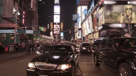 NEW YORK - APRIL 17, 2014: Uber town car driving through beautiful Times Square night in slow motion in 4K in New York. Times Square is an intersection and neighborhood in Midtown Manhattan, NYC, USA.
