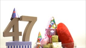 Number of age in a colorful studio setting with paper party hats, a hearts and gifts 