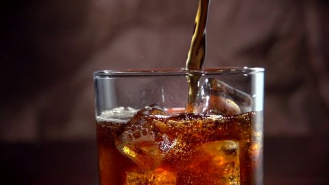 Cola with ice. Pouring Cola with Ice and bubbles in glass. Soda. Food background. Stock full HD video footage 1920x1080p. Slow motion 240 fps