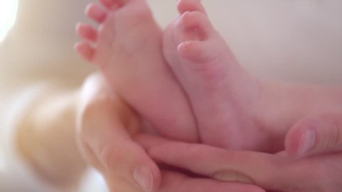 Baby feet in mother hands. Newborn Baby's feet on female Heart Shaped hands closeup. Mom and her Child. Happy Family concept. Beautiful conceptual video of Maternity. 1080p Slow motion. Slowmo 240fps Vídeo Stock