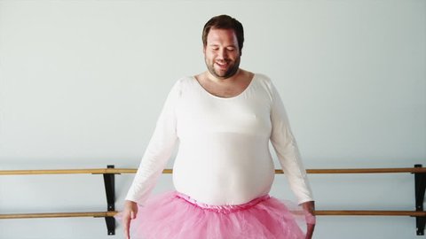 Medium Shot Overweight man wearing ballerina cosme practicing in ballet studio
