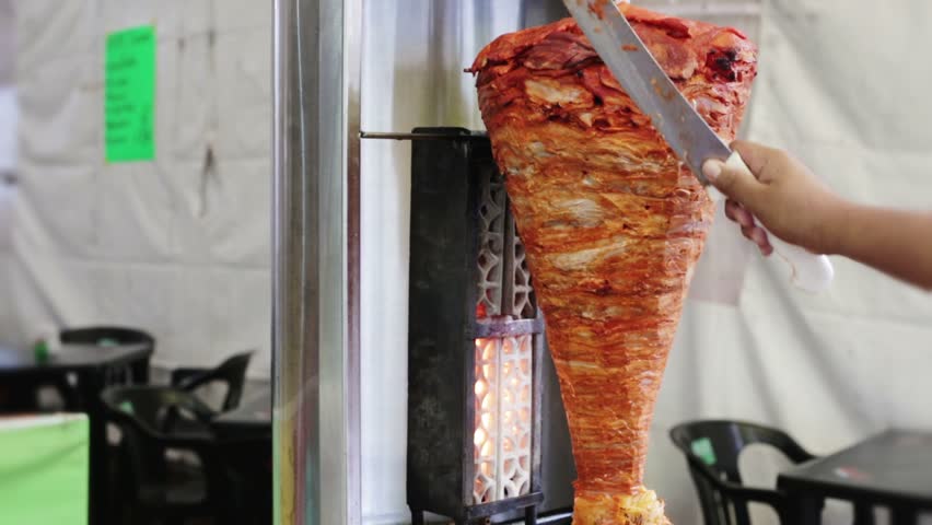 Slow roast vertical spit (al pastor) pork meat for tacos in Mexico