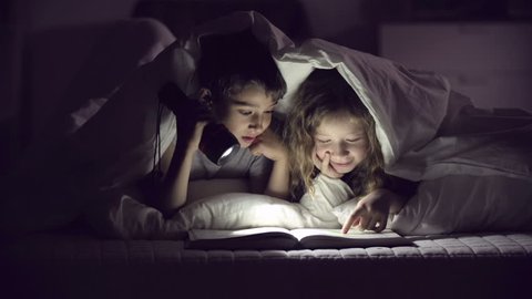 Children with flashlight reading