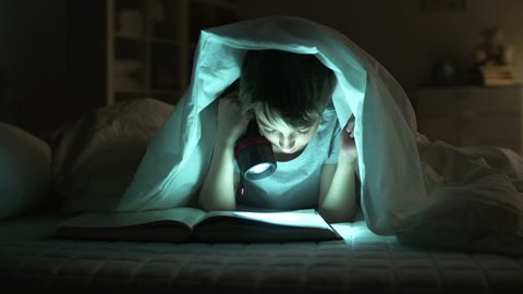 Dolly of boy reading aloud in bed