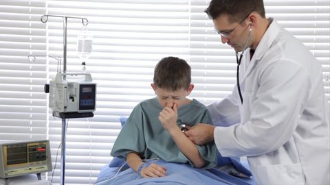 A pediatrician examines one of his hospitalized patients who is suffering with a severe cough.