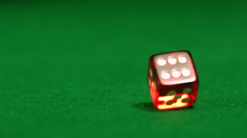 Close-up of red dice rolling on casino table in slow motion