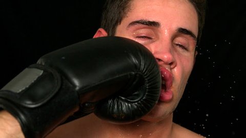 Portrait of tough Caucasian boxer taking a punch to the face in slow motion