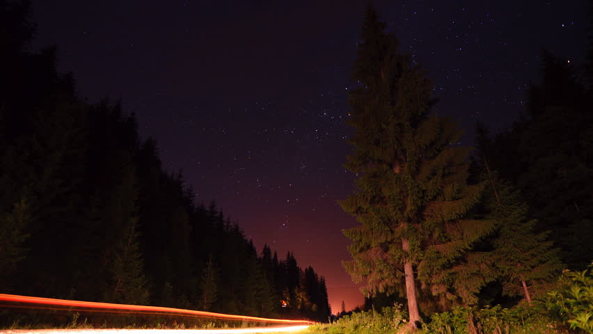 Star trails in the mountains forest road - moving stars star trails timelapse.
