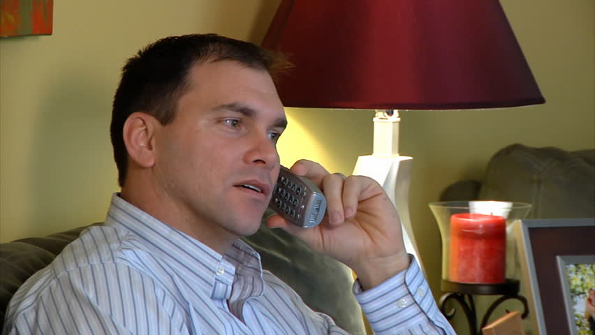 A man talks on a telephone.