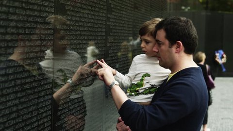 Medium Shot Father and son (4-5) at Memorial Wall, Vietnam Veterans Memorial, Washington D.C, USA