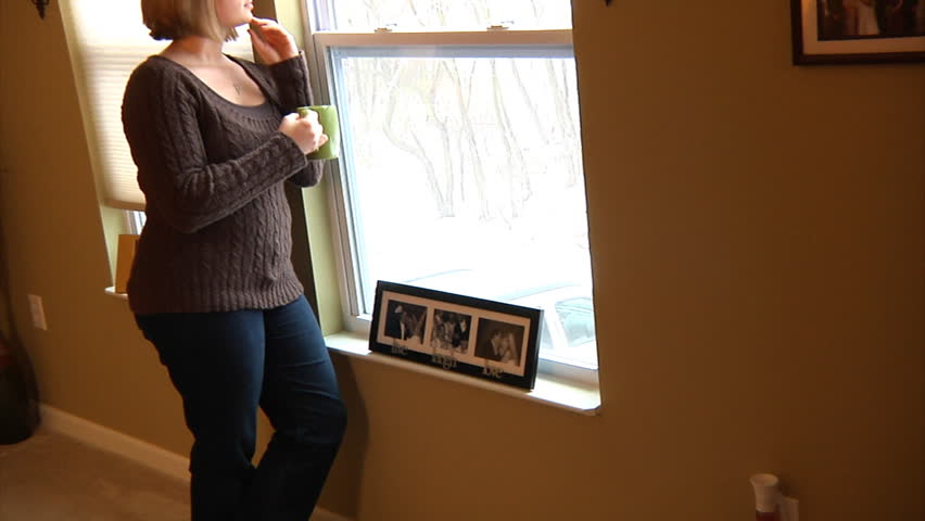 A depressed woman looks out a window.  Shot at 48fps.