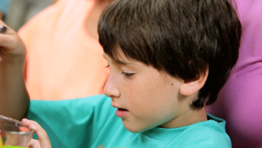 Healthy living Caucasian family together home kitchen counter head shoulders young son preparing freshly sliced organic fruit for electric blender close up