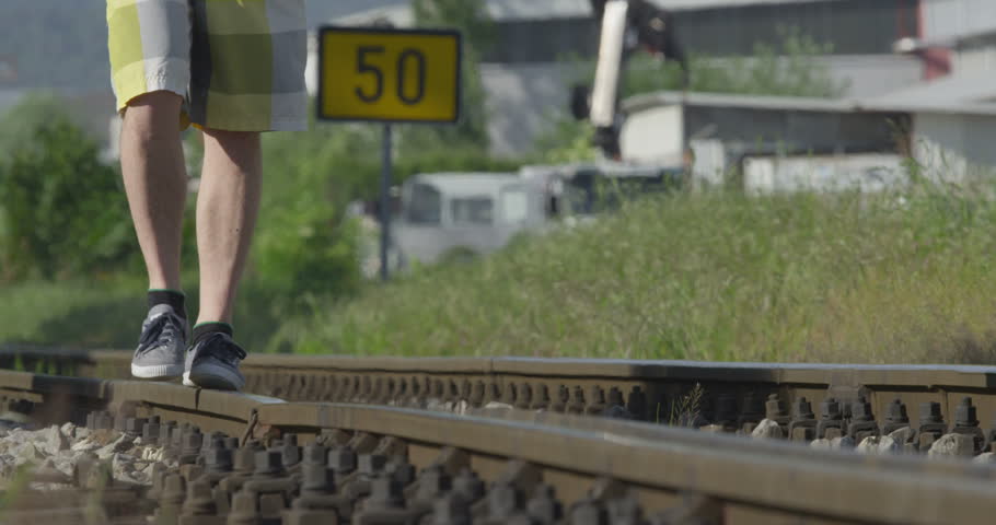 CLOSE UP: Walking on railroad tracks