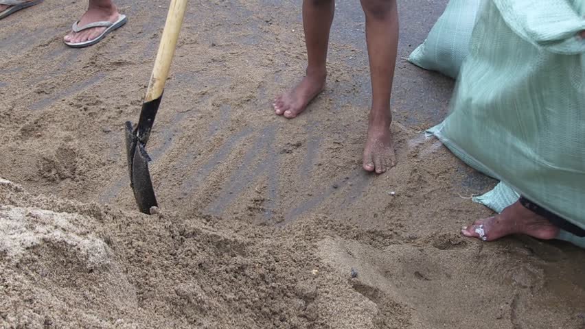 Volunteers filling bags with sand to build a sandbag dike for flood protection ( close up )