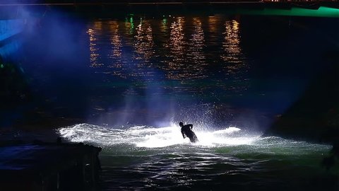 LJUBLJANA, SLOVENIA - MAY 2014: Octopus Fest. Water Scooter Doing Flips Under Lightshow. Two professional stunt jet ski driver making amazing flips and stunts on Ljubljanica river.