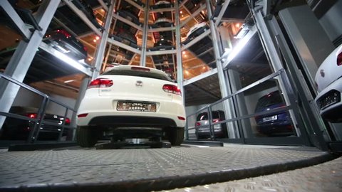 MOSCOW, RUSSIA - Jan 11, 2013: Rises lift with car and cars in garage of tiered car parking at night