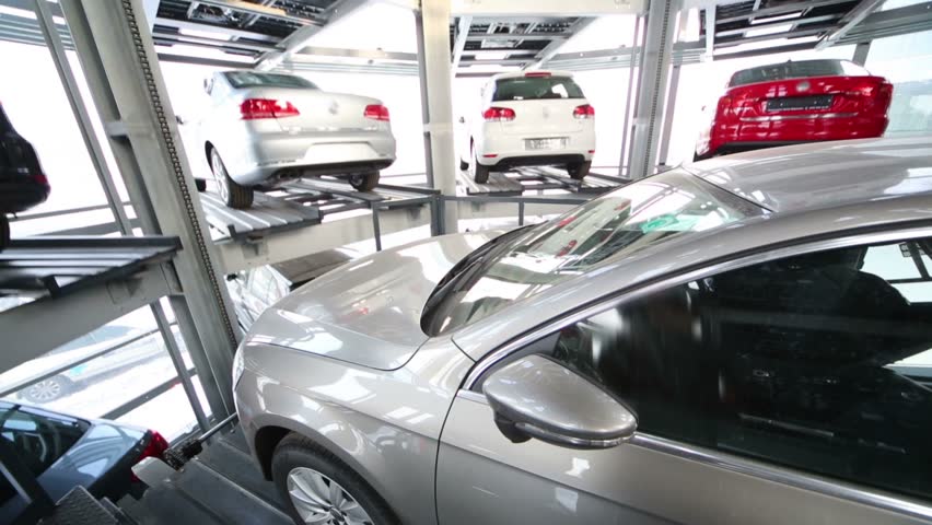 Car falls on elevator in modern glassy tower for car parking