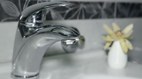 Tap Dripping. Water droplets at faucet.
Bathroom interior.