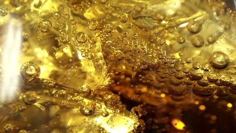 Pouring Cola with ice and bubbles in the glass. Close up soda soft drink. Food background. Slow motion filmed at 250 fps.