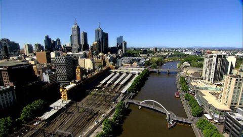 An aerial shot of Melbourne City, along the Yarra River past Flinders Railway Station and federation Square towards the MCG, Melbourne Cricket Ground